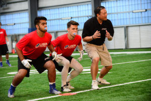 High School football player going through a leverage shoulder tackling drill.